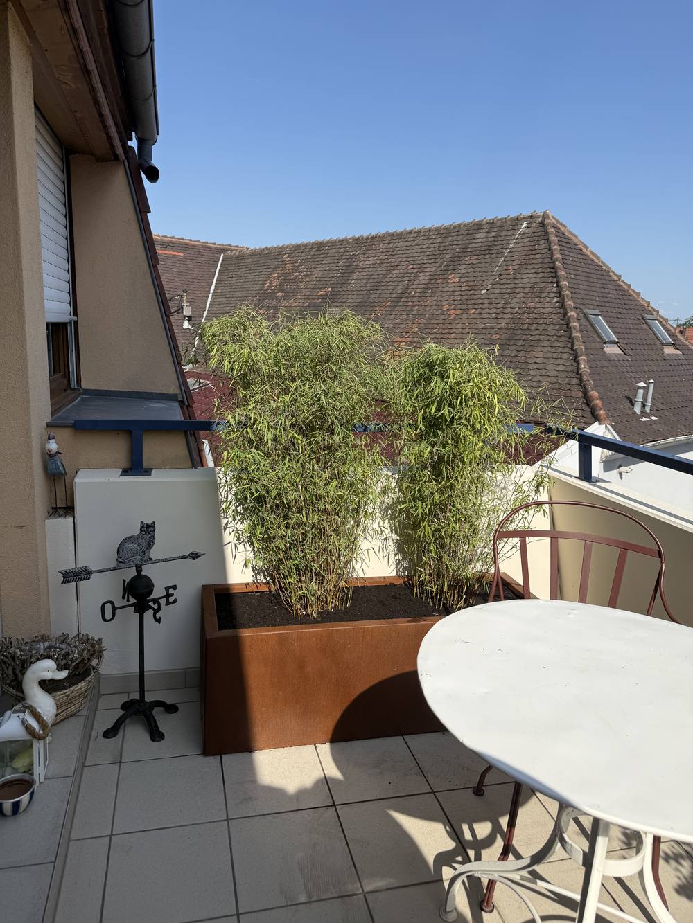 Terrasse aménagée avec jardinières en acier corten plantées de bambous